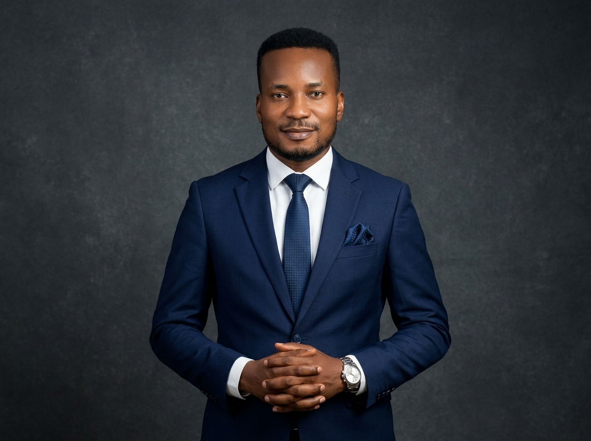 Amb. John Ifeanyi Amos in formal dark business suit in executive interior